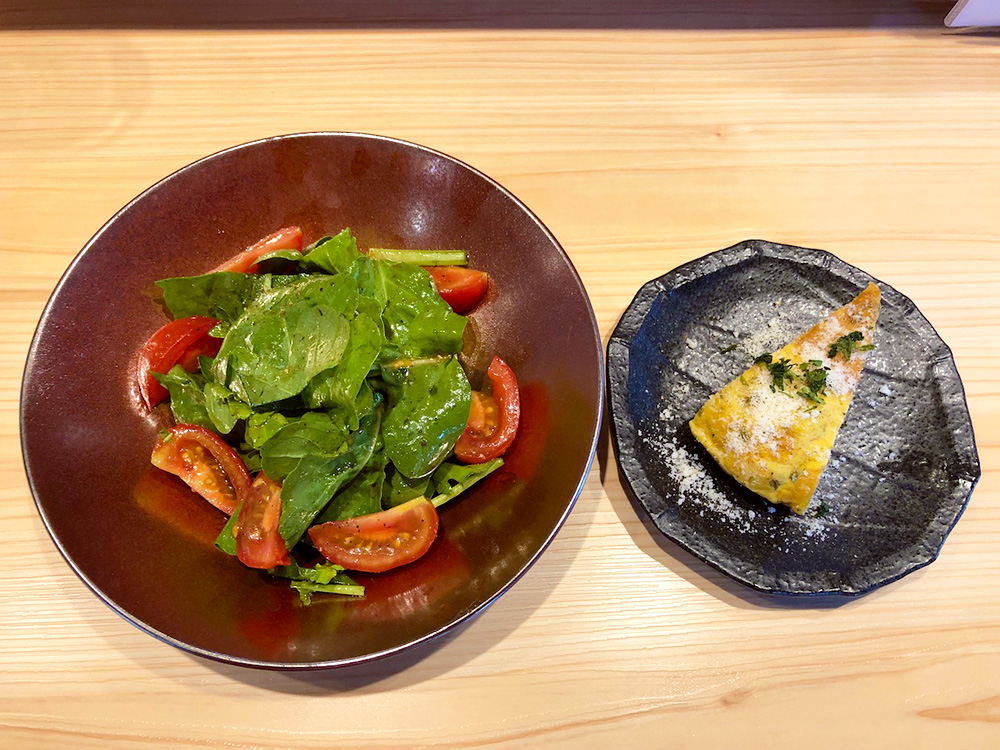 ルッコラとトマトのサラダ（左側）、フリッタータ（右側、イタリア版オムレツ）